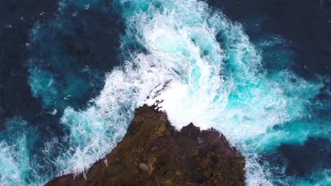 Cliff-with-waves-crashing-against-a-rocky-shore,-Nusa-Penida,-Indonesia.