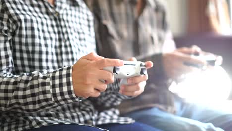 Male-and-female-hands-playing-video-game-at-home