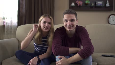 Young-couple-of-teenagers-watching-tv-at-home