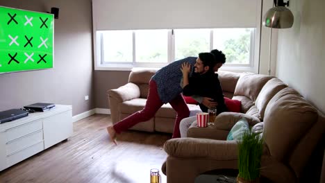 Happy-Gay-Couple-Watching-Sports-Game-On-TV-At-Home