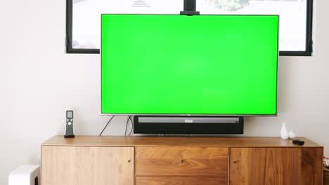 Rear-view-of-young-couple-sitting-on-sofa-at-home-and-watching-television