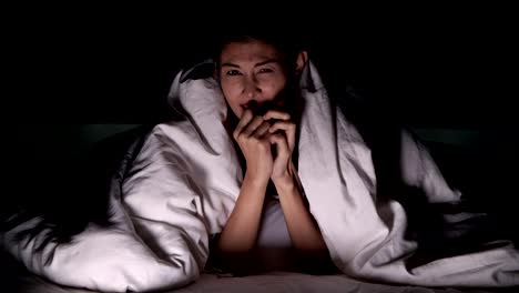 Frau-Horror-Film-allein-im-Bett.-Asiatische-Frau-liegend-im-Bett-allein,-Überraschung-und-Schock-von-scary-Movie.-Halloween-allein-Wohnkonzept.