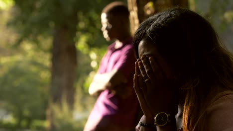 Pareja-africana-después-de-discutir-en-el-parque.-Silencio,-tristeza,-llanto