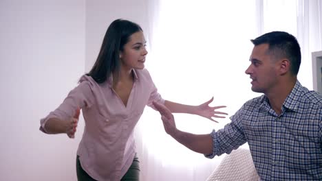 angry-dispute-in-married-couple,-Man-and-woman-swearing-each-other-during-quarrel-due-to-betrayal-and-aggressively-waving-hands-at-home