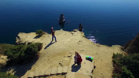 Two-Tourists-Taking-Photos-On-Cape-Fiolent-Cliff