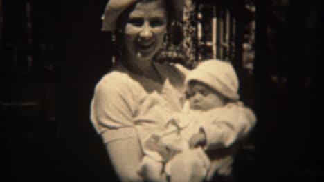 1937:-Mother-in-white-fashion-hat-holding-baby-daughter-in-matching-outfit.