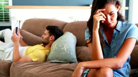 Couple-ignoring-each-other-in-living-room