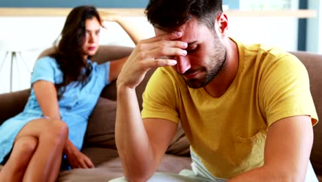 Couple-ignoring-each-other-in-living-room