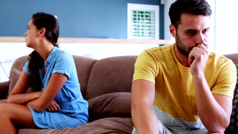 Couple-ignoring-each-other-in-living-room