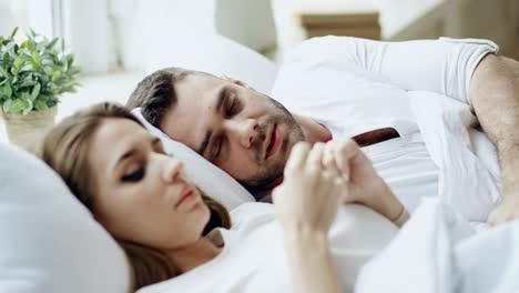 Closeup-of-couple-with-relationship-problems-having-emotional-conversation-while-lying-in-bed-at-home