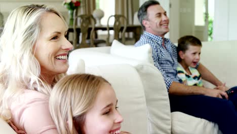 Happy-family-watching-television-together-in-living-room