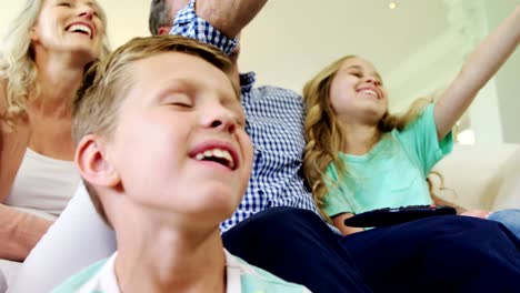 Happy-family-watching-television-together-in-living-room