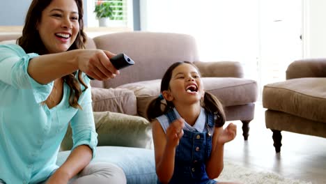 Mother-and-daughter-watching-television-in-living-room