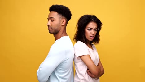 Young-afro-american-couple-standing-back-to-back-upset-and-disappointed-isolated-over-yellow-background