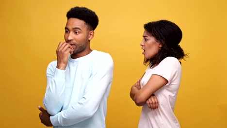 Young-afro-american-couple-having-a-fight-isolated-over-yellow-background