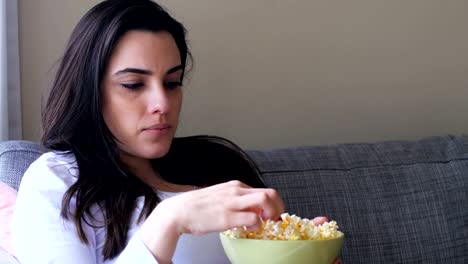 Frau-Essen-Popcorn-beim-Fernsehen-4k