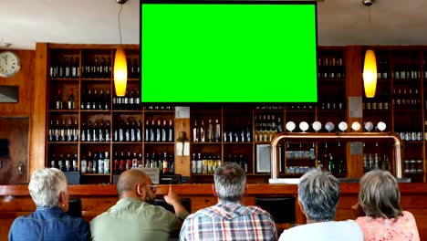 Glücklich-Freunden-vor-dem-Fernseher-in-der-bar-4k