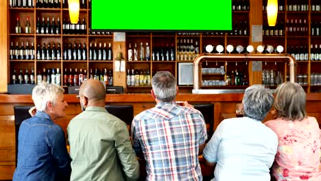 Happy-friends-watching-television-in-bar-4k