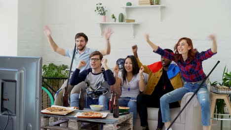 Heterogene-Gruppe-von-Freunden-sport-Fans-mit-französischen-Nationalflaggen-gerade-Wintersport-Spiele-im-Fernsehen-zusammen-Aufmunterung-Lieblingsmannschaft-zu-Hause