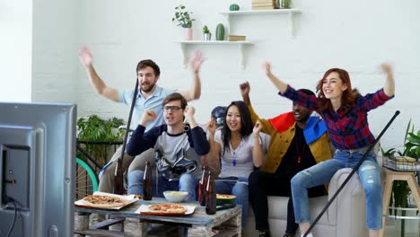 Gruppe-junger-Freunde-Sport-Fans-mit-französischen-Nationalflaggen-Sport-Meisterschaft-im-Fernsehen-zusammen-und-glücklich-über-den-Gewinn-der-Lieblingsmannschaft-zu-Hause-beobachten