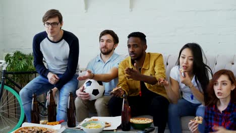 Young-friends-watching-football-game-on-TV-together-at-home-and-disappointed-about-their-favourite-team-losing-match