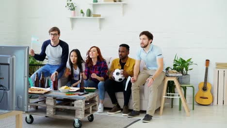 Amigos-felices-con-las-banderas-argentinas-ver-deportes-juegos-en-TV-junto-en-casa-y-felices-ganadora-del-equipo-favorito