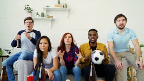 Amigos-jóvenes-felices-viendo-el-juego-de-deportes-en-la-TV-y-celebrando-la-victoria-del-equipo-favorito-en-casa