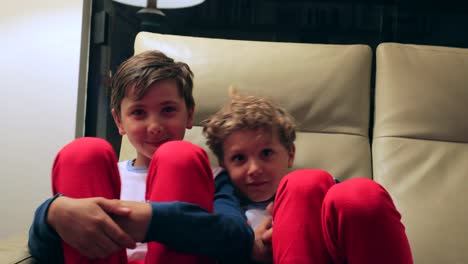 Boys-seated-on-sofa-watching-TV-off-camera.-4K-candid-clip-of-children-watching-screen