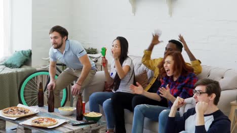 Slow-Motion-Gruppe-der-happy-Friends-Sportspiel-im-Fernsehen-zu-Hause-beobachten.-Sie-schreien,-während-ihre-Lieblings-Team-Wettbewerb-zu-gewinnen