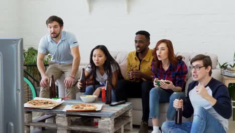 Slow-Motion-Gruppe-der-happy-Friends-Sportspiel-im-Fernsehen-zu-Hause-beobachten.-Sie-schreien,-während-ihre-Lieblings-Team-Wettbewerb-zu-gewinnen