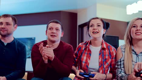 Happy-company-of-the-friends-enjoy-relaxing-by-playing-videogames-and-having-fun-indoor-in-modern-flat