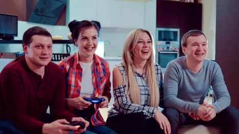 Glückliche-Gruppe-des-Lachens-männliche-und-weibliche-Freunde-spielen-von-Videospielen-mit-wireless-Controller