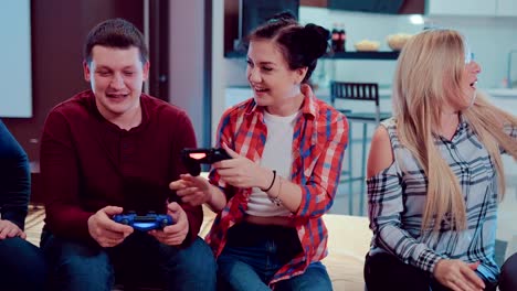 Happy-company-of-the-friends-enjoy-relaxing-by-playing-videogames-and-having-fun-indoor-in-modern-flat