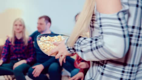 Freunden-auf-der-Couch-sitzen-und-Fernsehen,-eine-Freundin-verwöhnt-sie-mit-Popcorn,-sie-sind-sehr-freudig-überrascht,-glücklich,-Popcorn-Essen-und-Fernsehen-weiterhin