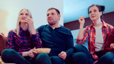 Compañía-de-amigos-viendo-la-televisión-con-palomitas-de-maíz