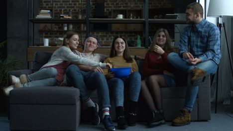 Group-of-teenagers-watch-comedy-movie-with-popcorn