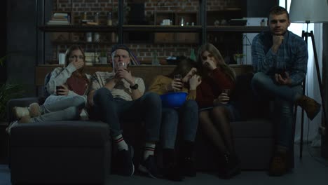 Group-of-friends-watching-horror-movie-at-home