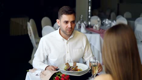 Young-bärtiger-Mann-ist-mit-seiner-Freundin-streiten,-während-des-Essens-im-Restaurant-dann-verlassen.-Liebhaber-Streit,-negative-Emotionen-und-Beziehungen-krisenkonzept.