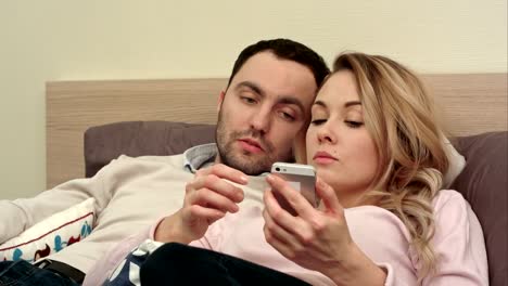 Pareja-joven-luchando,-discutiendo-en-la-cama-por-la-noche-debido-a-mensajes-de-texto-de-mujer-alguien-con-smartphone