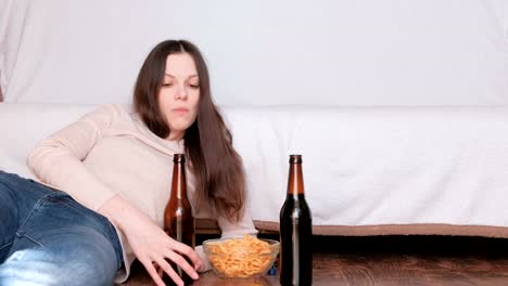 Pareja-de-joven-hombre-y-mujer-comiendo-fritas-bebiendo-cerveza-y-viendo-la-televisión.