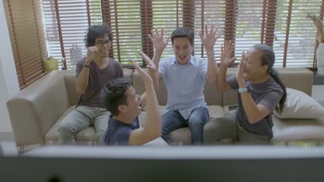 Group-of-asian-flat-mates-watching-sports-competition-on-TV-at-home