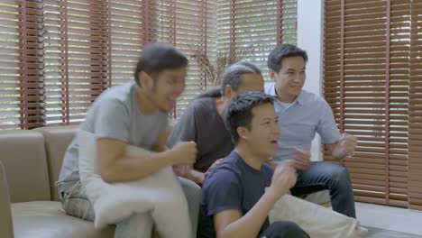 Group-of-asian-flat-mates-watching-sports-competition-on-TV-at-home