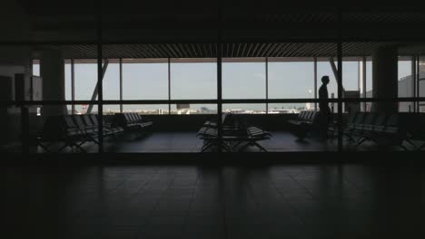 Silhouette-der-Mann-zu-Fuß-in-Flughafen-Wartebereich