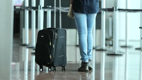 Persona-tira-la-maleta-en-el-aeropuerto.-Mujer-lleva-equipaje-en-4K