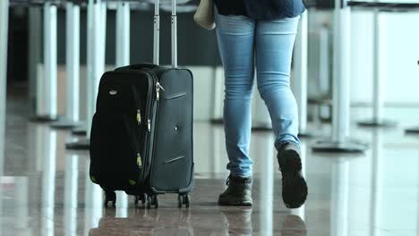 Persona-tira-la-maleta-en-el-aeropuerto.-Mujer-lleva-equipaje-en-4K