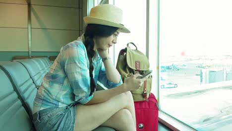 Passenger-woman-in-airport-using-smartphone