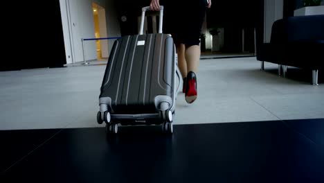 Business-woman-walking-with-wheeled-bag