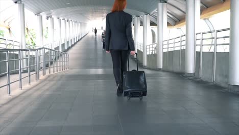 Slow-motion-shot-of-Back-of-Young-attractive-Asian-business-woman-dragging-a-wheeled-suitcase-at-the-airport-for-business-trip