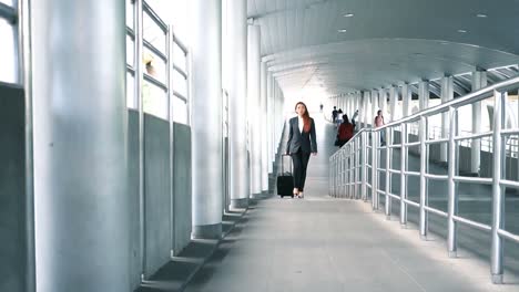 Slow-motion-shot-of-Back-of-Young-attractive-Asian-business-woman-dragging-a-wheeled-suitcase-at-the-airport-for-business-trip