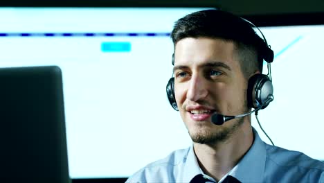 A-young-man,who-work-in-customer-service-or-in-some-airport-control-tower-station,-answers-calls-to-phone-customers-with-a-smile-day-and-night.